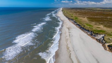 Yumuşak kumlu plajlar ve dramatik uçurumların yer aldığı Danimarka kıyı şeridi nefes kesici bir manzara. Dalgalar kıyıya vuruyor, Lyngvig deniz feneri Hvide Sande Kuzey Jutland
