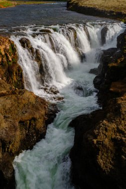 Güçlü şelaleler, İzlanda 'nın doğal güzelliklerini ön plana çıkaran Kolugljufur Kanyonu' nun engebeli kayalık arazisinde zarifçe akıyor. Bu büyüleyici manzara, sakin yabanın özünü yakalar..