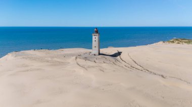 Rubjerg Knude deniz feneri, tarihi bir simge, Danimarka kıyılarındaki altın kum tepelerinin üzerindeki kuleler..