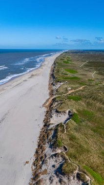 Geniş kumlu plajlar Danimarka kıyı şeridi boyunca uzanır ve kristal mavi denizle buluşur. Bereketli yeşil kumullar ve kayalık kayalıklar parlak bir gökyüzü altında çarpıcı bir doğal manzara yaratır..