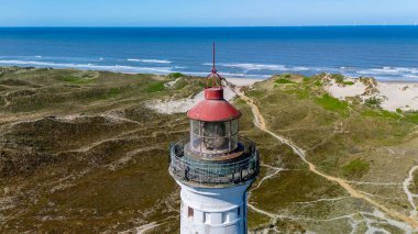 Danimarka 'nın sakin kıyı şeridine bakan deniz fenerinin nefes kesici manzarasına hayran kaldım. Bu pitoresk konum, Lyngvig deniz feneri Hvide Sande North Jutland 'ın kayan kum tepelerini içerir.