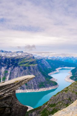 Büyüleyici panorama, yüksek uçurumlar ve karla kaplı dağlarla çevrili bir fiyordun zümrüt sularını sergiliyor. Doğa güzelliği tüm izleyicileri cezbeder, Trolltunga, Norveç 'teki keşifleri davet eder.