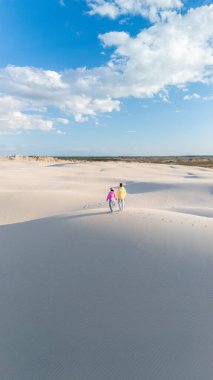 Sevgi dolu bir çift, barış dolu bir Danimarka plajının yumuşak, beyaz kumları boyunca el ele dolaşır. Parlak mavi gökyüzü ve yumuşak bulutlar huzurlu bir atmosfer yaratır, Rabjerg Mile Danimarka