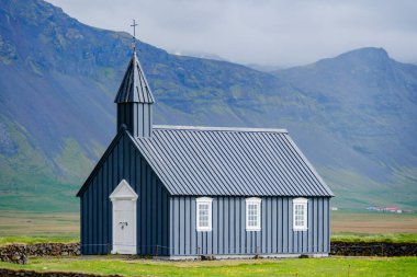 Dramatik dağların ortasında, çarpıcı bir siyah kilise İzlanda manzarasına gururla karşı duruyor. Budakirkja