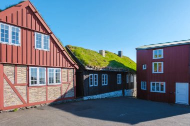 Faroe Adaları 'ndaki geleneksel mimarinin güzelliğini keşfedin. Çimen çatılı parlak renkli evler ve çarpıcı mavi gökyüzü. Bu cennet gibi yer ada yaşamının özünü yansıtıyor..