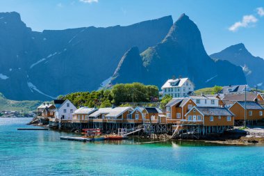 Norveç 'in çarpıcı kıyı şeridi boyunca uzanan canlı ahşap evler, temiz mavi suların güzelliğini yansıtıyor. Sakrisoy balıkçı köyü Lofoten Norveç
