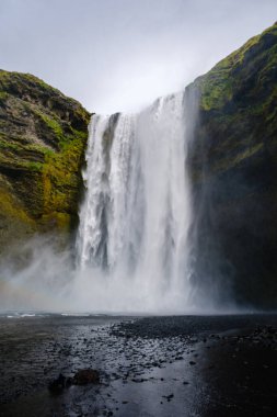 İzlanda 'daki Skogafoss şelalesinin nefes kesici manzarasını keşfedin. Suyun kayalıklardan zarif bir şekilde sisli bir vahaya yuvarlandığı yer. Doğa meraklıları ve fotoğrafçılar için mükemmel bir yer..