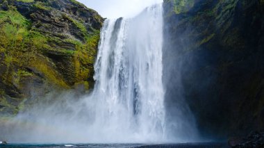 Su İzlanda 'daki Skogafoss Şelalesi' ne çarpıcı bir şekilde düşer ve sisli bir atmosfer yaratır. Yeşilliklerle çevrili bu nefes kesici doğa harikası bölgeyi keşfeden ziyaretçileri cezbediyor..