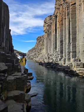 İzlanda 'da bulunan Studlagil Kanyonu' nda nefes kesici bazalt oluşumlar ve yüksek uçurumlar arasında akan sakin bir nehir yer alıyor..