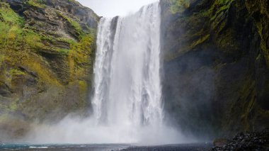 İzlanda 'daki Skogafoss şelalesi kayalıklardan yemyeşil ve engebeli arazilerle çevrili sisli bir havuza dalarak nefes kesici bir doğa harikası yaratır..