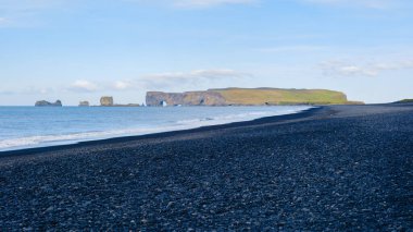 Reynisfjara Sahili 'nin eşsiz siyah volkanik kumları dramatik kayalıklar ve deniz yığınlarıyla çevrilidir. Huzurlu atmosfer ve nefes kesici manzara mükemmel bir kaçış sağlar..
