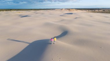 Danimarka 'da resim gibi kum tepecikleri arasında el ele gezeriz. Uçsuz bucaksız beyaz kumlar açık mavi gökyüzü ile çok güzel tezat oluşturuyor, Rabjerg Mile Kumulları, Danimarka.