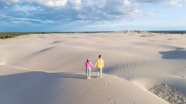 Danimarka 'nın engin, pürüzsüz, beyaz kum tepelerinde altın saat boyunca el ele dolaşırlar. Yumuşak ışık huzurlu ve romantik bir atmosfer yaratır. Manzaralı bir kaçış için mükemmel..