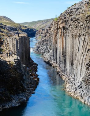 İzlanda 'daki Studlagil Kanyonu' nun nefes kesici güzelliğini tecrübe edin. Çarpıcı bazalt kaya oluşumları ve canlı turkuaz suları. Maceracılar ve doğa severler için mükemmel..