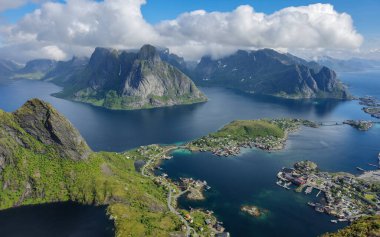 Norveç Lofoten Adaları 'ndaki sakin sulardan heybetli dağlar çarpıcı bir şekilde yükselir..