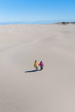 İki birey el ele geziyor Rabjerg Mile Danimarka 'nın geniş kum tepelerinde güneşlenerek ılık ve huzurlu atmosferin tadını çıkarıyorlar.. 