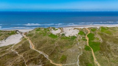 Danimarka 'nın kıyı şeridi boyunca uzanan kumullar sakin bir kaçış sunuyor. Açık mavi gökyüzünün altında denizin hafif dalgaları, Lyngvig deniz feneri Hvide Sande North Jutland 'da
