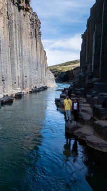 Ziyaretçiler, kristal berrak suların üzerinde yükselen bazalt sütunların olduğu Studlagil Kanyonu 'nun nefes kesici güzelliğine hayret ediyorlar. Bu jeolojik mucize İzlanda 'nın eşsiz manzarasını gözler önüne seriyor..