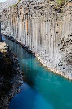 İzlanda 'daki Studlagil Kanyonu' nun eşsiz bazalt sütunlarına hayranlık duyuyorum. Mavi sular yüksek uçurumlardan akıyor. Bu doğa harikası hem maceraperestleri hem de fotoğrafçıları cezbeder..