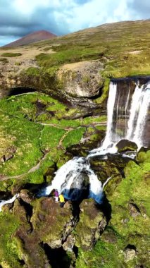 İzlanda 'nın canlı yeşilliklerle çevrili Selvallafoss şelalelerini keşfedin. Tanık yürüyüşçüleri doğa güzelliğine ve bu sakin manzarada çağlayan suyun rahatlatıcı sesine hayran kalırlar..