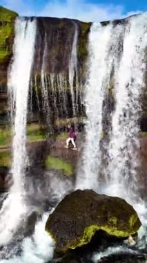 Ziyaretçiler, İzlanda 'daki Selvallafoss Şelalesi' nin tabanında yürürler ve büyüleyici doğal güzelliklerle çevrilidirler. Şelale gibi akan su macera ve keşif için büyüleyici bir atmosfer yaratır..