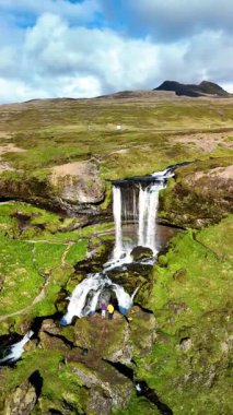 İzlanda 'nın nefes kesen güzelliğini tecrübe edin şelaleler yeşil tarlalarda zarafetle yuvarlanırken. Doğaya huzurlu bir kaçış, bereketli araziyi ve manzaranın zengin dokularını gözler önüne seriyor..