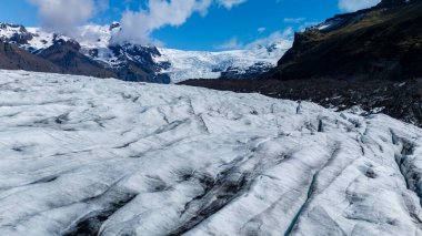 İzlanda 'daki Svinafellsjokull Buzulu' nun geniş buz oluşumlarına hayret ediyorum. Açık mavi gökyüzü altında karmaşık desenler ve çarpıcı doğal güzellikler sergiliyor. Açık hava maceraları için mükemmel..