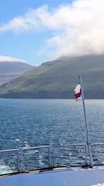 İzlanda 'nın nefes kesici kıyı manzarasını deneyin, yuvarlanan tepeler kristal berraklığında sularla buluşur parlak mavi gökyüzünün altında.