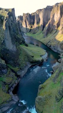 İzlanda 'daki Fjadrargljufur Kanyonu' nun sarmal bir nehrin üzerinde sarp kayalıkların yükseldiği nefes kesici güzelliğini tecrübe edin..