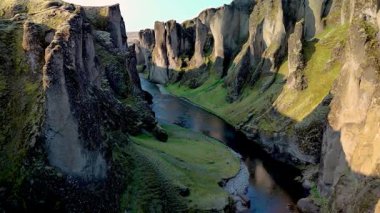 Görkemli Fjadrargljufur Kanyonu 'nu keşfedin. Yeşilliğin yükselen kayalıklarla ve sakin sularla buluştuğu yeri. İzlanda 'da macera arayanlar için mükemmel olan bu İzlanda mücevherinin ihtişamını deneyimlemek.