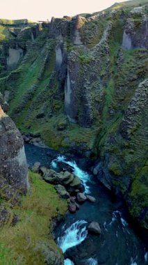 İzlanda 'daki Fjadrargljufur Kanyonu' nun çarpıcı manzarasına tanık olun. Yüksek uçurumlar ve dolambaçlı bir nehir doğanın mükemmel bir uyumunu yaratır..