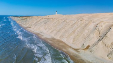 Rubjerg Knude deniz feneri Kuzey Jutland Danimarka 'daki kumlu kayalıkların ve sakin kıyı sularının çarpıcı karışımını keşfedin.