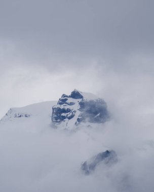 Svinafellsjokull Buzulu 'nun büyüleyici manzarası yoğun bulutlarla kaplanarak sakin ve bulutlu bir günde İzlanda' nın dramatik buzlu zirvelerini ve engebeli arazisini gözler önüne seriyor..