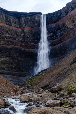 Hengifoss şelalesi, renkli kaya katmanları ve kayalık nehir yatağıyla çevrili sarp kayalıklardan zarifçe düşer. Bu nefes kesici İzlanda manzarası saf güzelliği gözler önüne seriyor..
