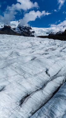 Svinafellsjokull Buzulu 'nun geniş manzaraları berrak gökyüzünün altında parlayan engin buzul alanını gözler önüne seriyor. Engebeli dağlar İzlanda 'nın kalbindeki bu hayret verici doğa harikasını çerçeveletiyor..