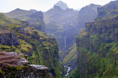 İzlanda 'daki Mulagljufur Kanyonu' nu çevreleyen görkemli kayalıklar canlı yeşil manzaralar ve çağlayan bir şelale sergiliyor. Bu manzaralı yer, el değmemiş doğanın nefes kesici manzarasını sunuyor..