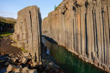 Studlagil Kanyonu 'nun eşsiz bazalt sütunları ve Icealdn' daki canlı yeşil sularıyla karakterize edilen nefes kesici manzarasını keşfedin.