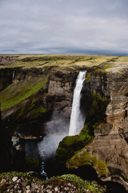 Haifoss şelalesi, İzlanda 'nın vahşi doğasındaki yemyeşil ve kayalık arazilerle çevrili sarp kayalıklardan çarpıcı bir şekilde düşer. Bu doğal mucize bölgenin saf güzelliğini gözler önüne seriyor..