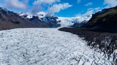 İzlanda 'daki Svinafellsjokull Buzulu' nu keşfedin, yüksek dağların arasında karmaşık buz oluşumları bulunmakta. Doğa aşıkları ve fotoğrafçılar için mükemmel bir yer..