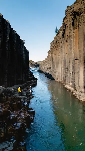 Studlagil Canyon, İzlanda 'daki kristal berrak suların üzerinde eşsiz bazalt kaya oluşumları kulesi doğa sanatını ortaya çıkarıyor. Ziyaretçiler, çarpıcı jeolojik özelliklerle çevrili bu uzak mücevheri keşfediyorlar..