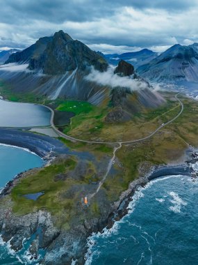 İzlanda 'nın çarpıcı manzarasını keşfetmek, bulutlarla örtülü yüksek dağları, dolambaçlı bir yolu ve büyüleyici bir kıyı şeridini keşfetmek. Hvalnes İzlanda