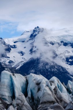 Buz ve kardan oluşan katmanlar Svinafellsjokull Buzulu 'nu süslüyor, yüksek tepeler ve dramatik bir gökyüzü ile çevrili. Bu büyüleyici doğa harikası İzlanda tundrasının güzelliğini gözler önüne seriyor..