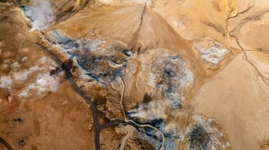 İzlanda 'nın çarpıcı jeotermal özelliklerini keşfedin. Yeryüzünden buhar yükselir ve canlı renkler büyüleyici bir manzara yaratır..