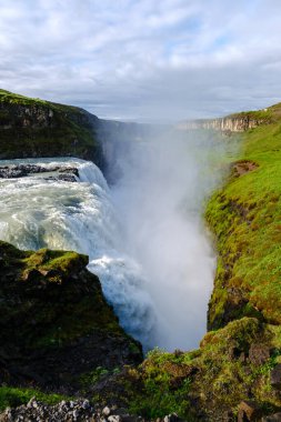 Nefes kesen Gullfoss şelalesi, bereketli yeşilliklerle çevrili derin bir kanyona dökülen doğanın gücünü gösteriyor. Şelaleden sis yükselir, açık bir günde mistik bir atmosfer yaratır..