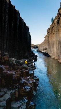 Canlı maceracılar, bazalt sütunları ve ışıl ışıl bir nehirle çevrili, çarpıcı Studlagil Kanyonu 'nu keşfeder. Bu nefes kesen mekan doğanın ortasında korku ve maceraya ilham veriyor..