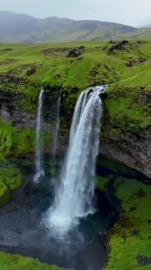 Seljalandsfoss şelalesine tanık olun. Suyun yeşilliklerle çevrili kayalıklardan zarifçe yuvarlandığı yere. Bu ikonik İzlanda doğal harikası macera ve keşfi davet ediyor..