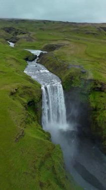 Yaz boyunca İzlanda 'nın güneyindeki volkanik bir dağdan akan Skogafoss şelalesinin dramatik manzarası