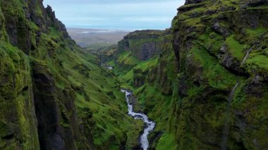 İzlanda 'daki Mulagljufur Kanyonu' nun nefes kesici güzelliğini keşfedin, yemyeşil kayalıklar ve kıvrımlı bir nehir.
