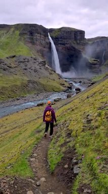 Bir yürüyüşçü, İzlanda 'nın en nefes kesici şelalelerinden biri olan Haifoss' a uzanan yemyeşil araziyi keşfeder. Sakin atmosfer ve çağlayan su, doğaya mükemmel bir kaçış sunuyor..