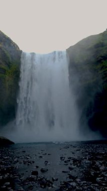 Skogafoss şelalesi kayalıkların üzerinden dramatik bir şekilde akar ve sisli bir atmosfer yaratır. Yeşillik ve manzarayla çevrili bu büyüleyici doğa harikası ziyaretçileri cezbediyor..